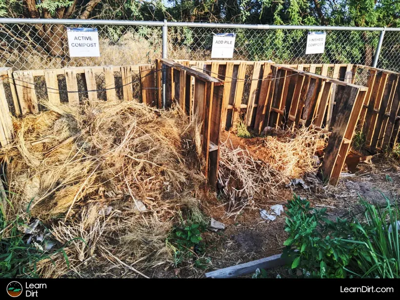 compost system 3 bays made from wooden pallets in garden with drip lines